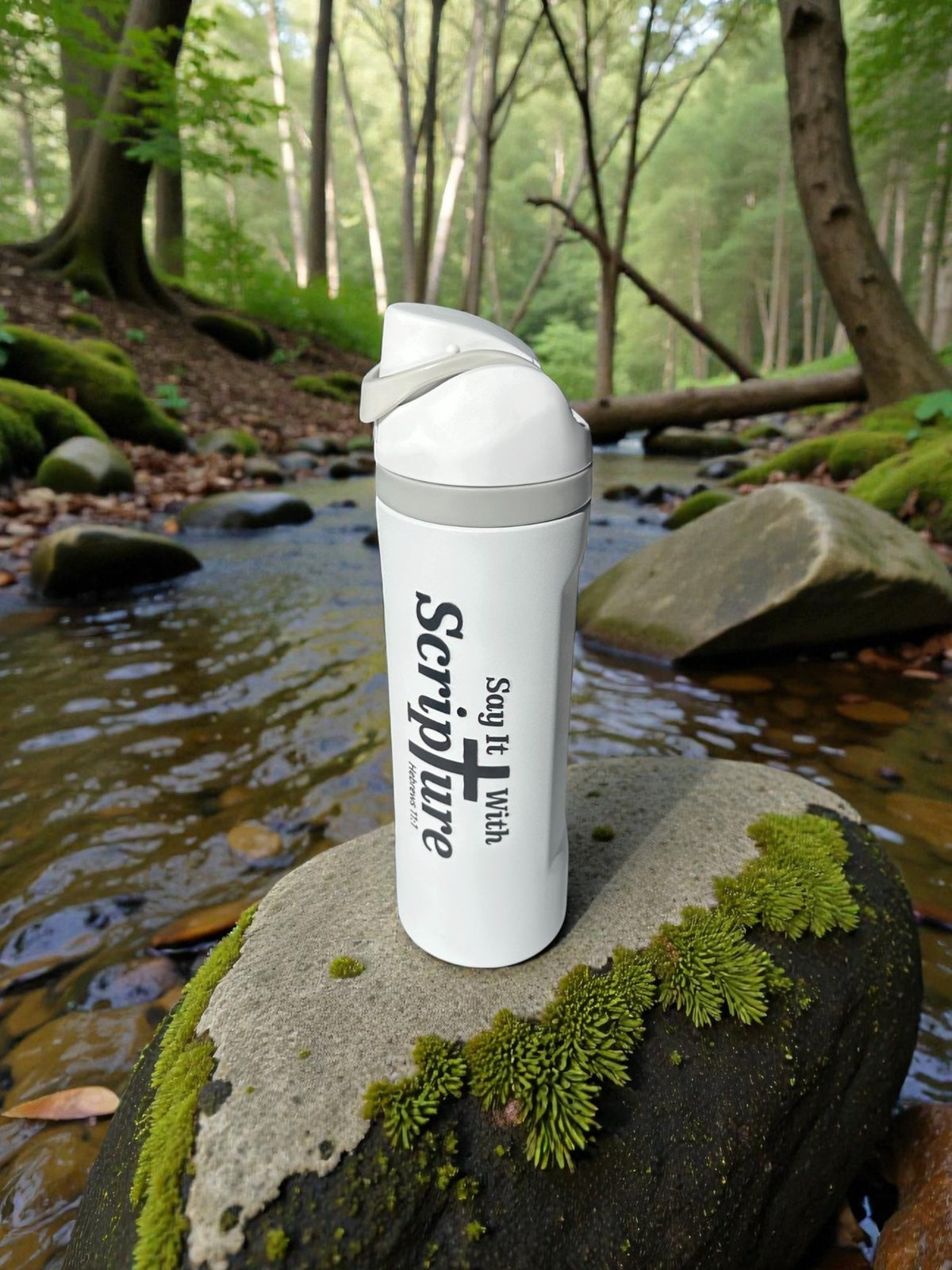 White branded Scripture flask by woodland stream